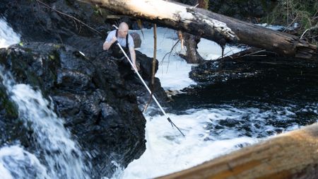Troy Brockway fishes for salmon with a dip net. (National Geographic/Mickey Ramos)