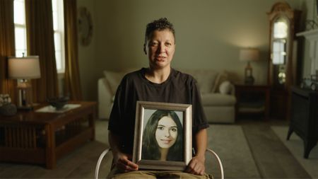 Margo Gomez holds a photo of her mother, Sindy Gina Crow. (National Geographic/Will Francome)
