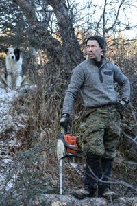 Joel Jacko constructs a small wooden bridge to help him cross a narrow part of his hunting trail. (National Geographic/Wayne Shockey)
