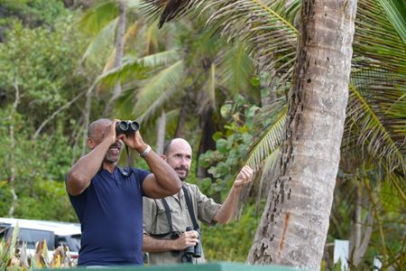 Christian Cooper watches the elegant White-Tailed Tropicbird from the shore with biologist Alcides Morales. (National Geographic for Disney)