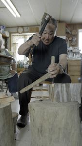 John Pingayak carving a bird out of wood for his grandchildren. (National Geographic/Matt Kynoch)