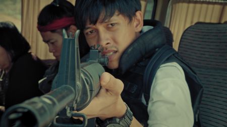 A reenactment of one of the students who held 89 people hostage at the Embassy of Myanmar in Central Bangkok, 1999. In this moment, the student points an AK-47 to the negotiator's head who in turn refuses to negotiate with a weapon pointed at him. (©2019 MCN International Pte Ltd. All Rights Reserved.)