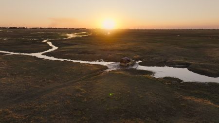 A car crossing the water channels of the the Busanga Plains. (National Geographic)