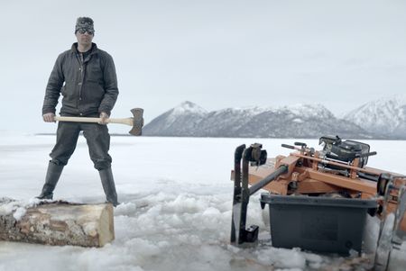 Joel Jacko chops wood to mill into planks. (National Geographic/Wayne Shockey)