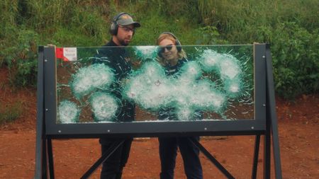 Mariana van Zeller and Jose look at the damage the bullets caused to the glass in Johannesburg, South Africa. (National Geographic)