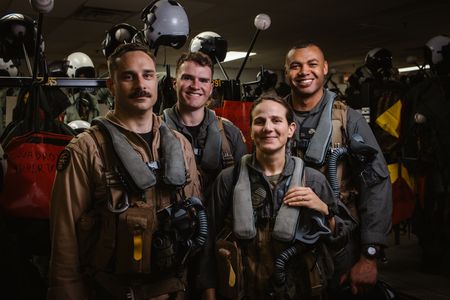 Students Spenser Neel, LTJG Dylan Horan, Captain Steph Harris, and Captain Micah Nissly pose together in the paraloft. (Credit: National Geographic/Freddie Claire)