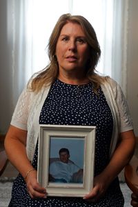 Melissa Slates, half-sister of the doe Michael Leach, holds a photo of her brother. (National Geographic/Andrew Thompson)