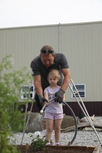 Art Reinhold helps Abigail Pol water a plant in the new garden at the Pol family's farm. (National Geographic)