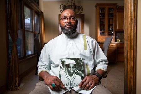 Tariq el-Amin, Imam of Masjid Al-Taqwa mosque in Chicago, IL, holds a photo of his cousin, Kaif Bismillah (birth name Keith Lavell Bibbs). (National Geographic/Tom Beard)