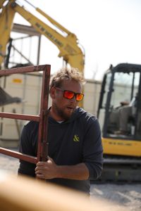 Ben Reinhold carries a metal fence to finish the construction of the sheep hut's swale that will help with the flooding. (National Geographic)