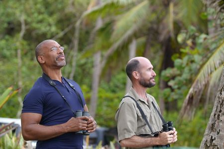 Christian Cooper watches the elegant White-Tailed Tropicbird from the shore with biologist Alcides Morales. (National Geographic for Disney)