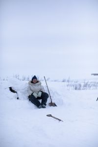 Agnes Hailstone shovels snow to help set up their family camp in Kiwalik. (BBC Studios Reality Productions/Ashton Hurlburt)
